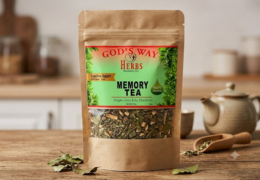 A stand-up kraft paper pouch of God's Way Herbs Memory Tea stands on a wooden table with a blurred kitchen background, including a teapot and cups. The pouch has a green and red label with a clear window showing dried herbal tea inside.